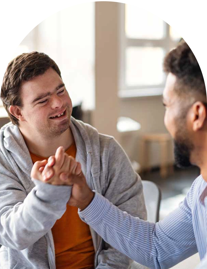 support worker shakes hands with man with disability